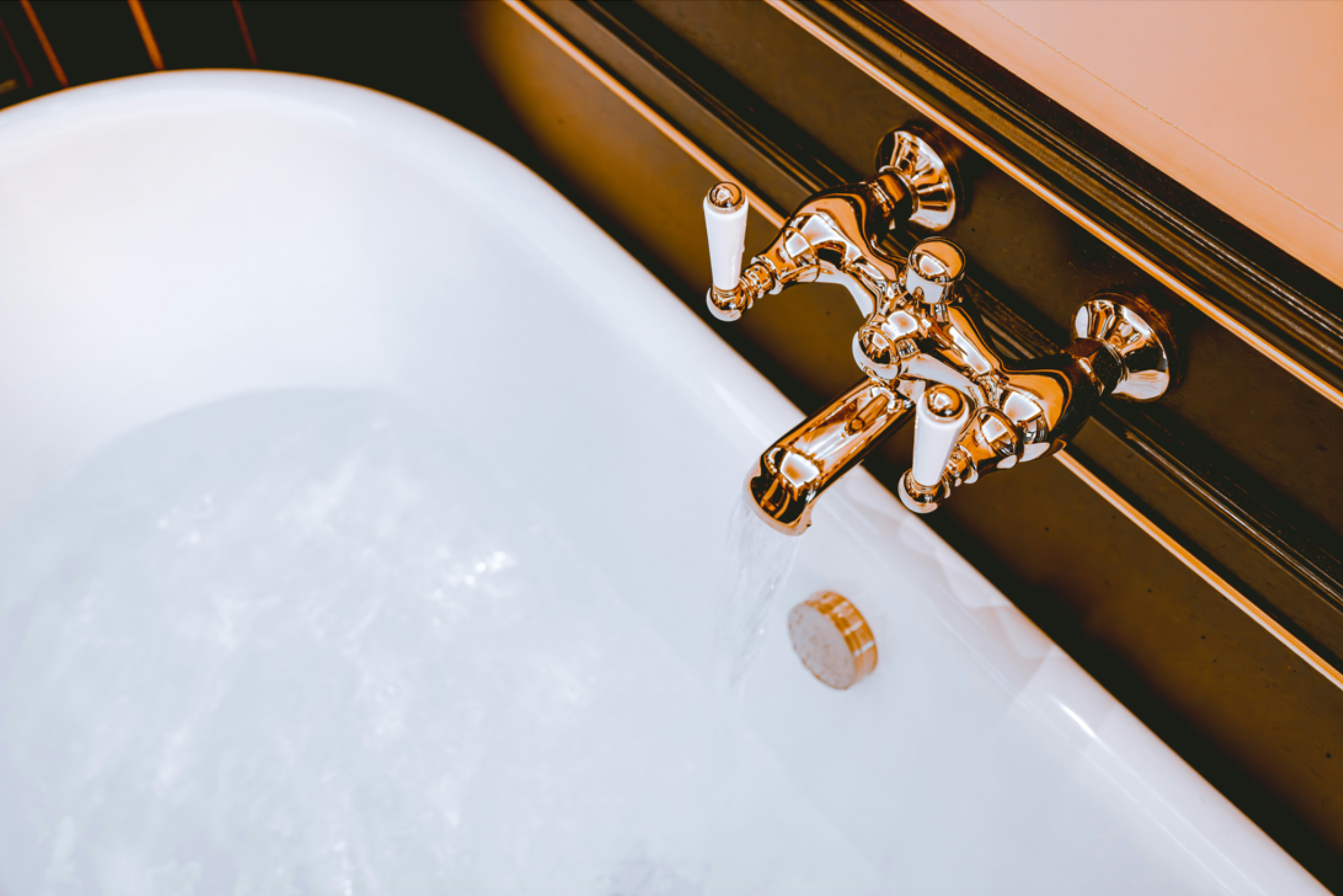 Gold faucet on a white sink with a black cabinet