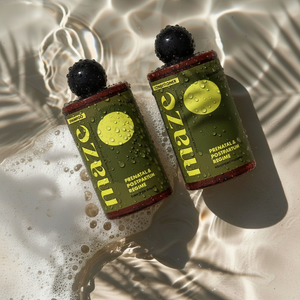 Two bottles of Maze prenatal and postpartum regime on a textured surface with water droplets.